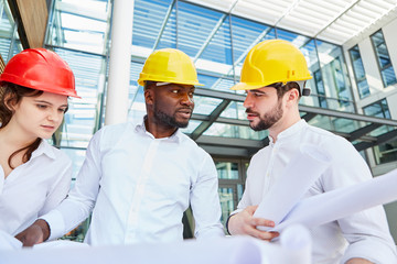 Bauleiter redet mit Architekt und Ingenieurin