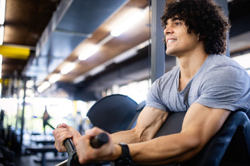 Fototapeta na wymiar Fit healthy handsome man exercising in modern gym