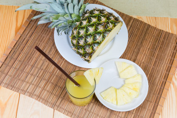 Top view of pineapple juice, slices and part fresh pineapple