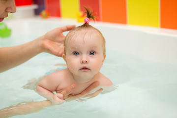infant swimming,Mother teaching baby to swim in water pool,Little baby's first swim 