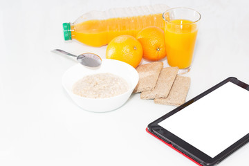 Healthy Breakfast with muesli and orange juice. Top view on light background with tablet to copy space.