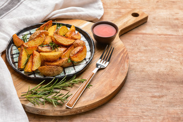Plate with tasty baked potato and sauce on wooden table