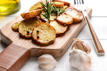 Board with tasty baked potato on white table