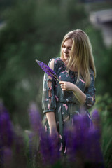 Young blonde girl with long hair lying in the grass.  Blonde on a green background in nature.