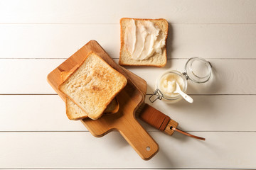 Coconut oil with tasty toasted bread on white table