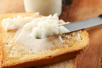 Coconut oil on tasty toasted bread, closeup