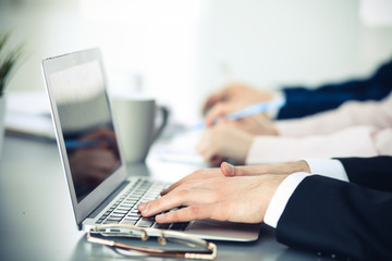 Group of business people working together in office. Man hands typing on laptop computer