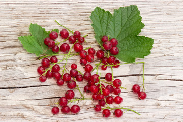 Redcurrant berries with leaves on an old wooden surface