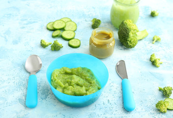 Bowl and jars with healthy baby food on table