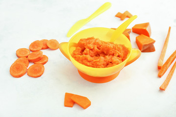 Bowl with healthy baby food on table
