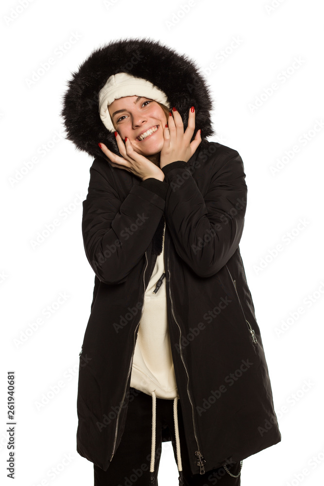 Poster Young model in winter jacket with hood posing on white background