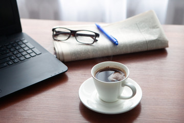 Newspaper with computer on table. Coffee break. 