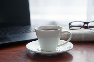 Newspaper with computer on table. Coffee break. 