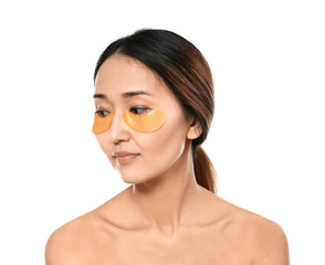 Asian woman with under-eye patches on white background