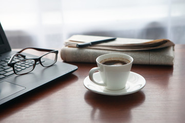 Newspaper with computer on table. Coffee break. 