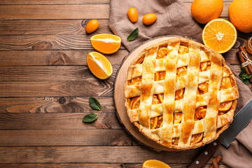 Tasty orange pie on wooden background