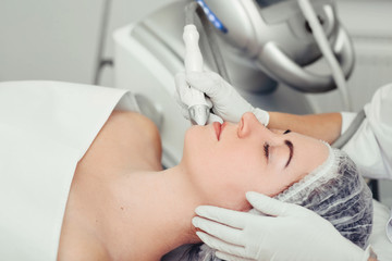 Obraz na płótnie Canvas woman receiving no-needle high frequency mesotherapy at beauty salon. non-invasive procedure for skin rejuvenation