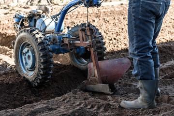 A man working in the field. A man plows the land with motor cultivator