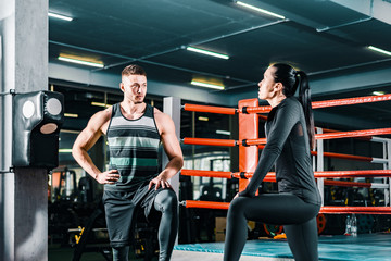 Athletic man talking to a sports woman in the gym. fitness workout. communication between people.