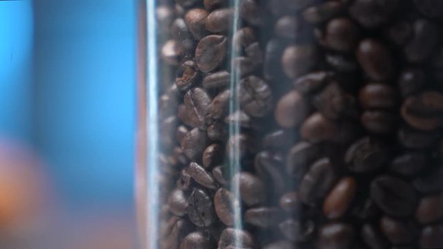 Black Coffee Grains. Black coffee is laid out on a bag spinning on a stand around its axis.