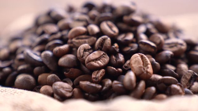 Black Coffee Grains. Black coffee is laid out on a bag spinning on a stand around its axis.