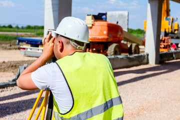 Civil engineer, geodesist is working with total station on a building site