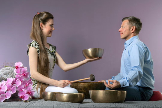 Ayurveda Therpeutin beim Anschlagen von Klangschale, innere Harmonie durch Klang und Schwingungen