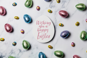 Easter egg compostition. Chocolate foil easter eggs around an easter message