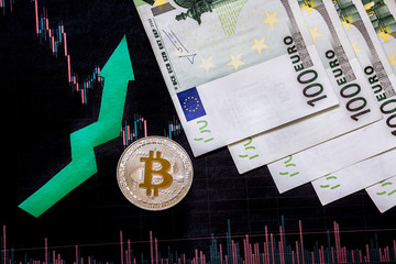 appreciation of virtual money bitcoin. Green arrow and silver Bitcoin on hundred euro bills and paper forex chart index rating on exchange market background. Concept of appreciation of cryptocurrency.