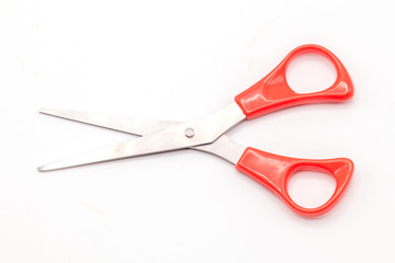 Red scissor on isolated white background.
