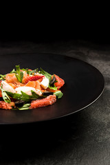Healthy salad on dark plate.Restaurant dish,healthy eating