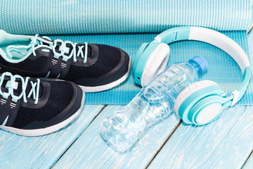 Yoga Mat, sports shoes, water bottle on blue background concept of healthy living, healthy eating, sports and diet