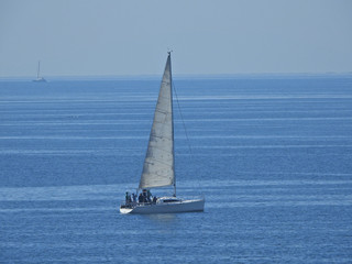 Zoom photo of sail boat sailing the Aegean deep blue sea