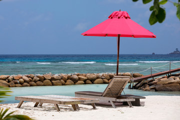 Liegestühle und roter Sonnenschirm am Strand, Seychellen, Afrika