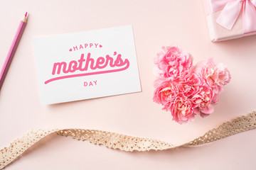 top view of carnation with card on pink background
