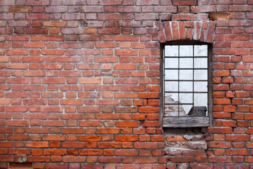 Window with bars on the background of the brick wall of the old house