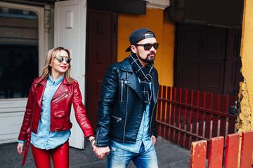 Sexy couple in leather jacket and sunglasses walking in city street