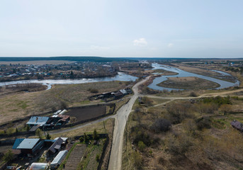 Old houses and Iset river in Kamyshevo village. Aerial