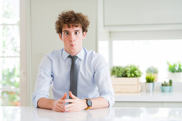 Young business man wearing a tie making fish face with lips, crazy and comical gesture. Funny expression.