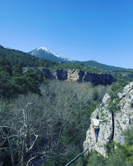 A man is walking along a stretched sling. Highline in the mountains. Man catches balance....