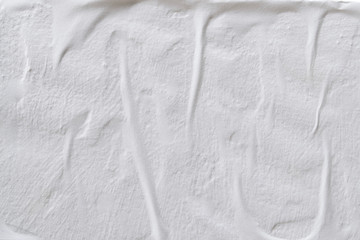 A sheet of white paper glued on an uneven surface.