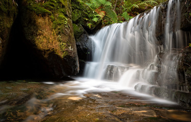 Fototapeta premium Waterfall in lush mountain gully