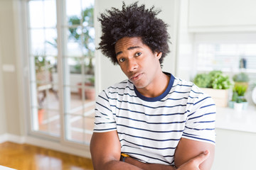 African American man wearing stripes t-shirt skeptic and nervous, disapproving expression on face...