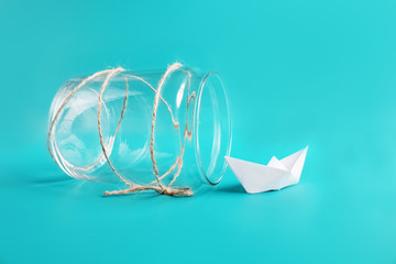 Freedom, release and dreams art concept. Paper ship in jar. Isolated on blue background. Copy space