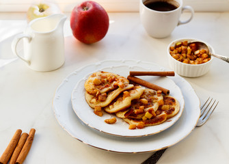 Stack of pancakes with honey and apple on white table, delicious dessert for breakfast.