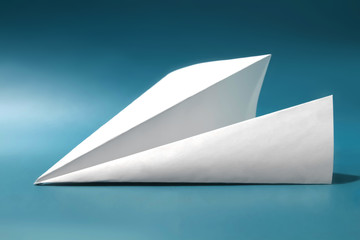 White paper plane on dark blue color background