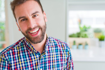 Handsome man wearing colorful shirt and smiling positive at the camera