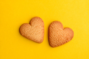 Two heart cookies on yellow