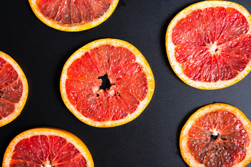 Sliced grapefruit on a dark background pattern