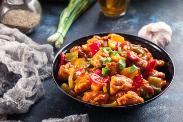Sweet and sour chicken with colorful bell pepper on a plate - 261962695